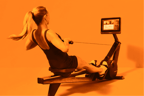 woman finishing a stroke on the Hydrow Rower in a bright, modern room