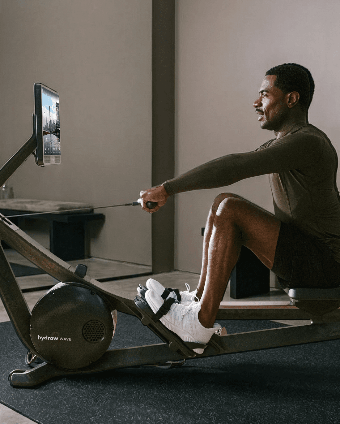 A person rowing on a Hydrow Wave in a sunlit room