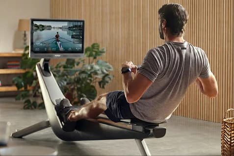 man rowing on the Hydrow Rower in a bright, modern room